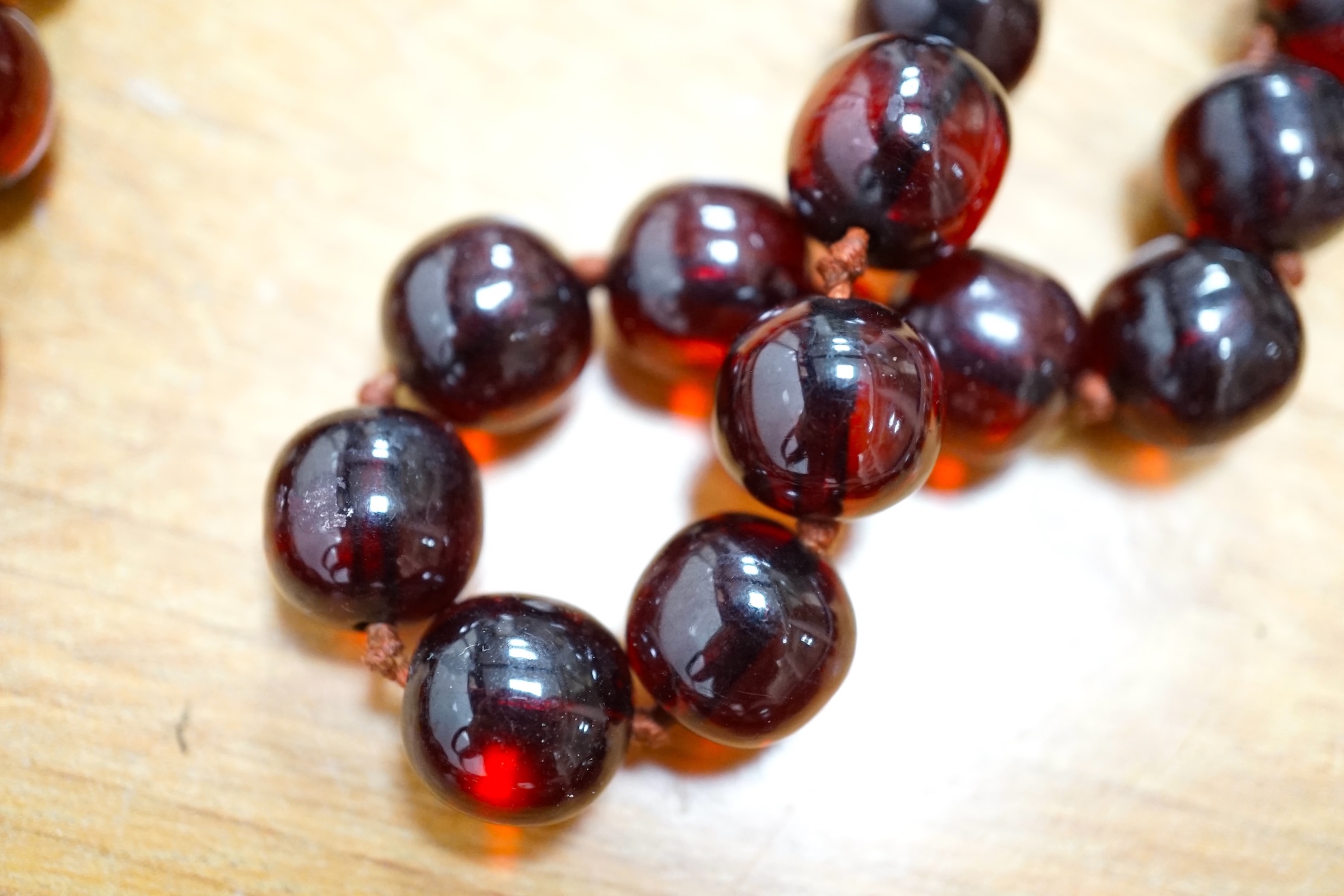 Two single strand simulated cherry amber bead necklaces, including one graduated string, 38cm, gross weight 173 grams. Condition - fair